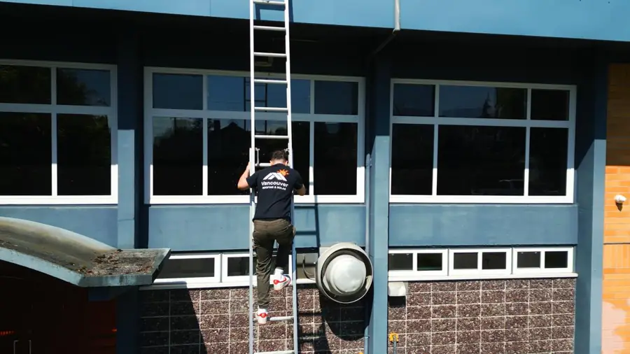 Vancouver Roofing & Solar crew member on a ladder at a North Vancouver job