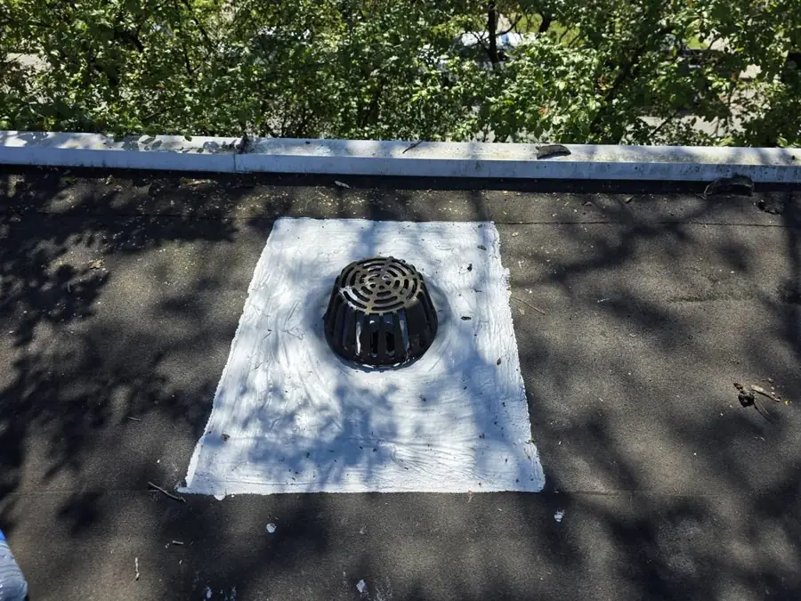 Roof drain cleared and resealed during a roof maintenance visit
