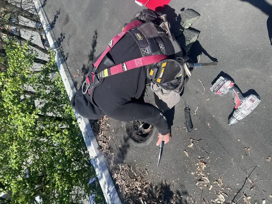 Crew member secured by fall-arrest harness working on a flat roof edge